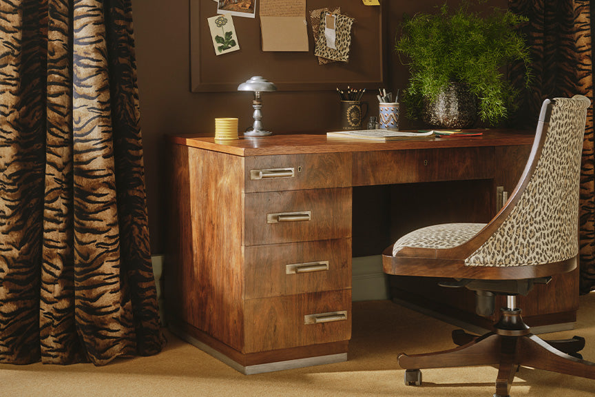 a desk with a chair and a cork board