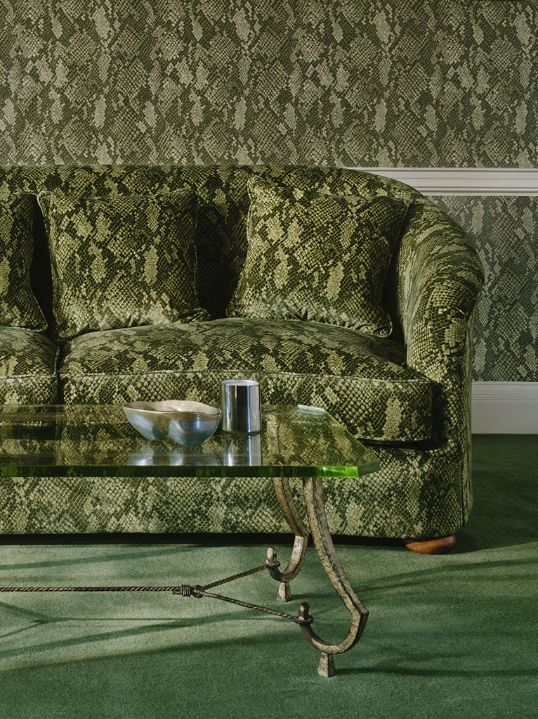 a green couch with a glass coffee table