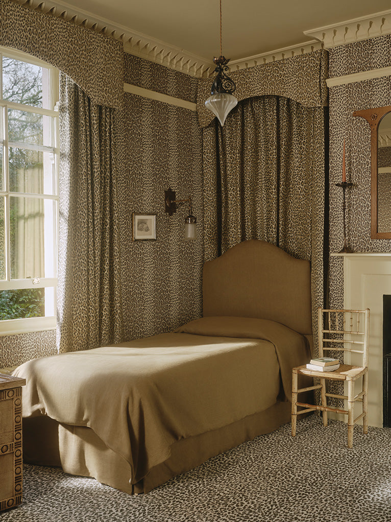a bedroom with leopard print walls and a bed