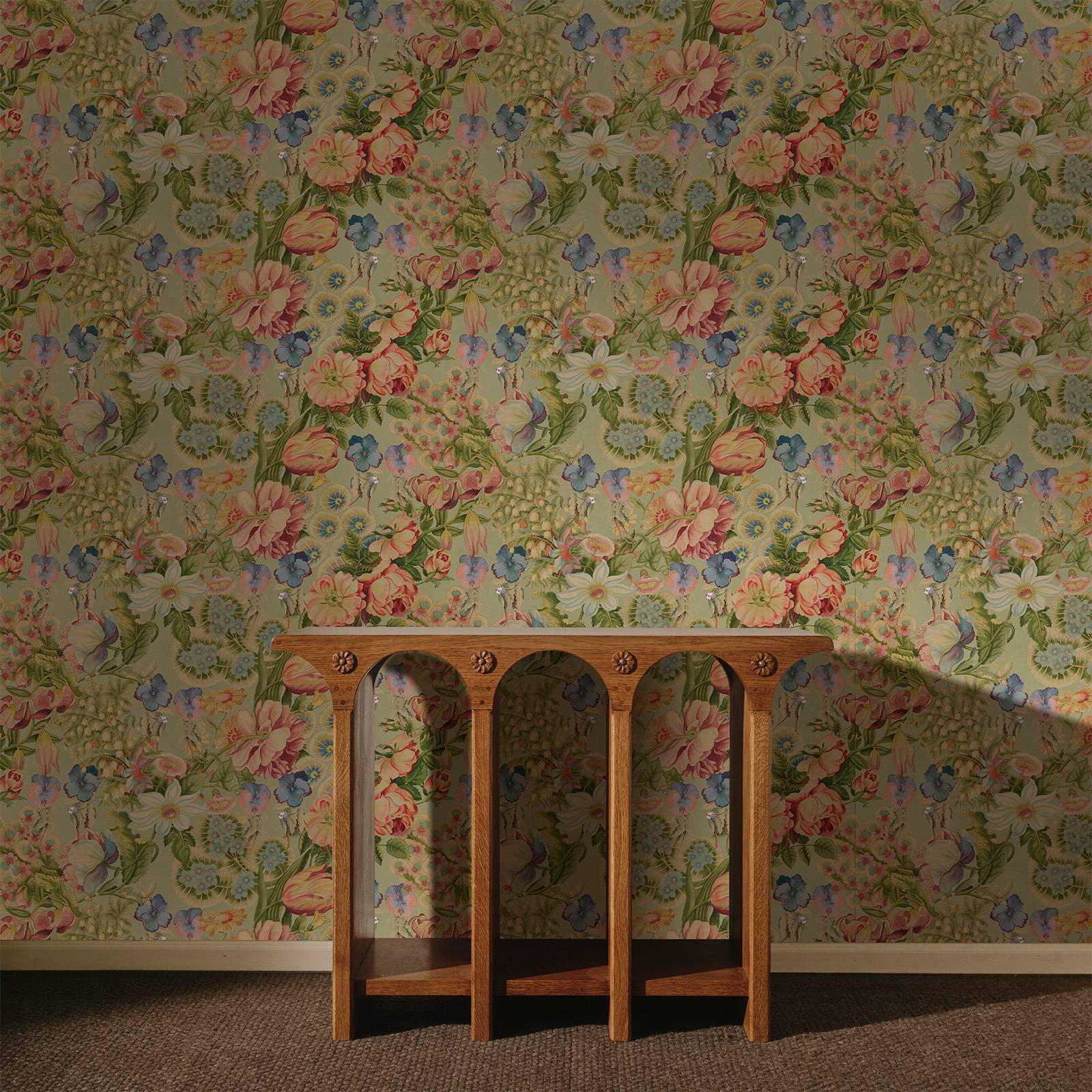 a wooden table in front of a floral wallpaper