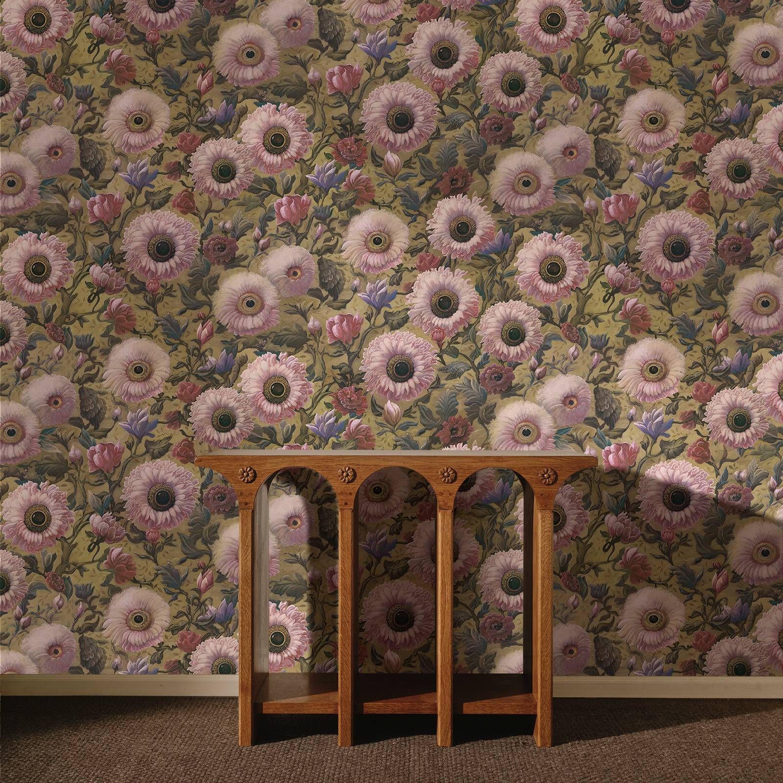 a wooden table against a wall with a floral wallpaper