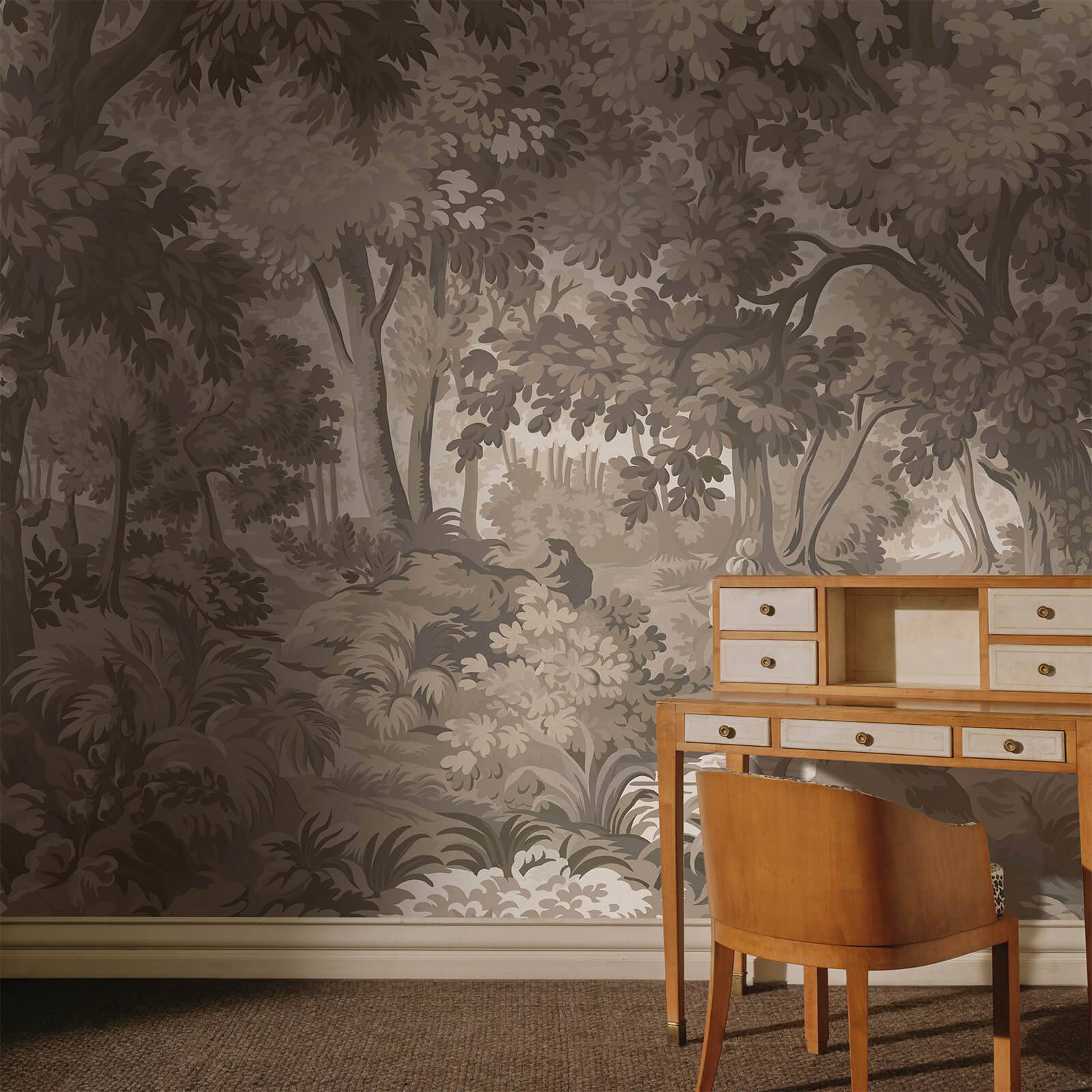 a desk and chair in front of a wall with trees on the wall