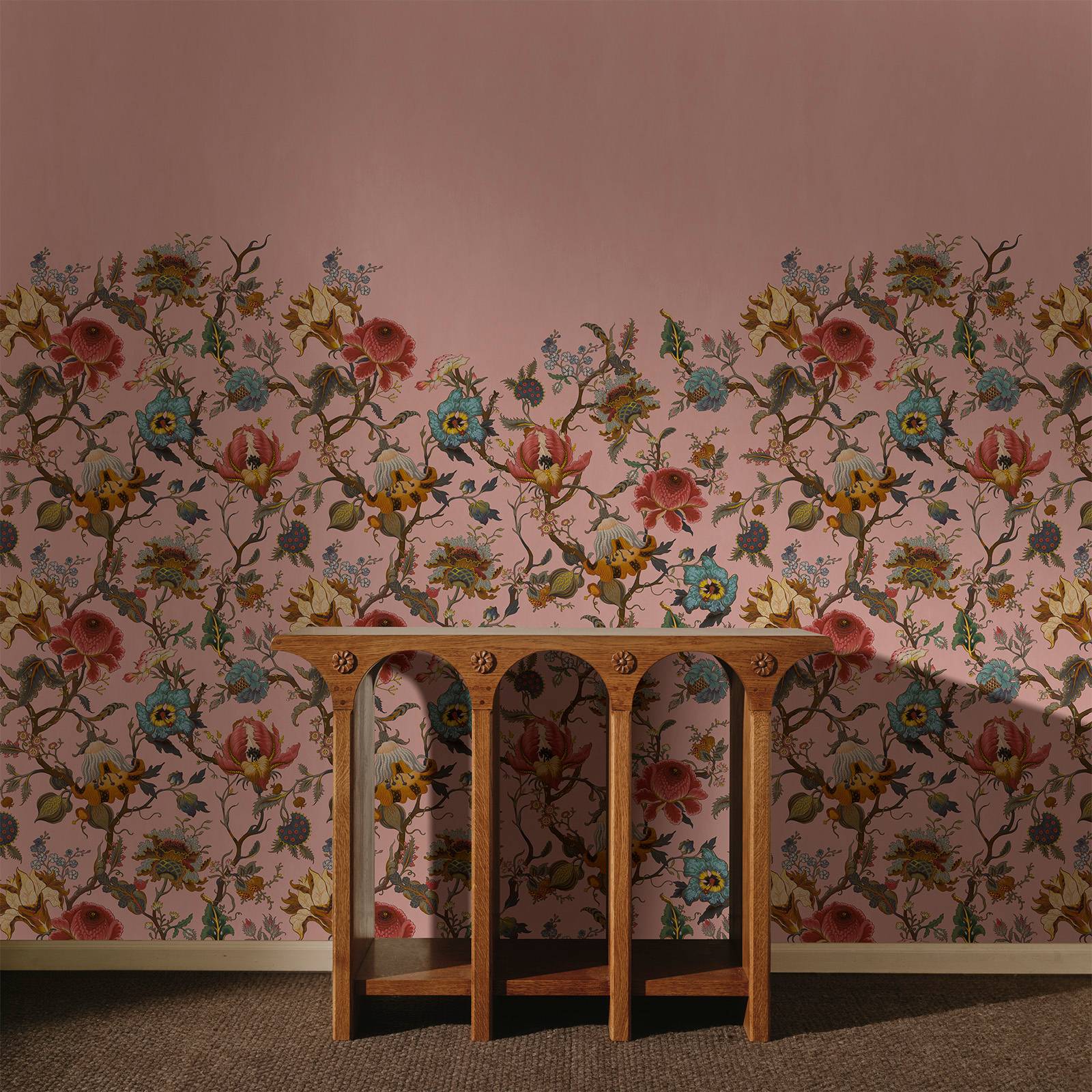 a table in front of a wall with floral wallpaper