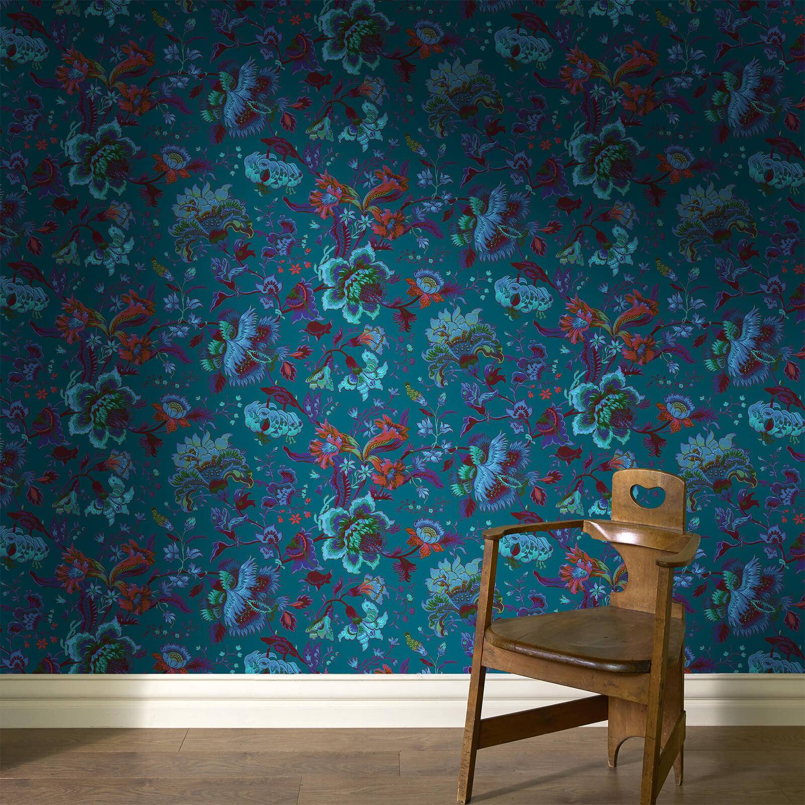 a chair in a room with a floral wallpaper