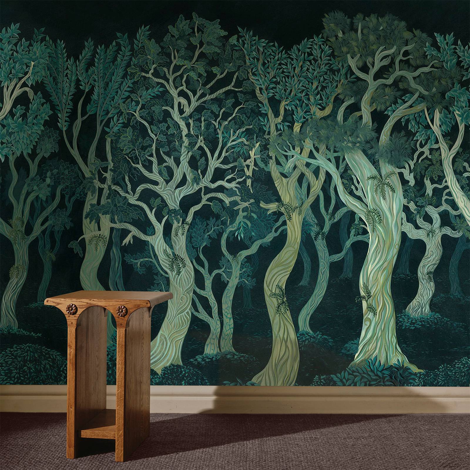 a table next to a wall with trees on it