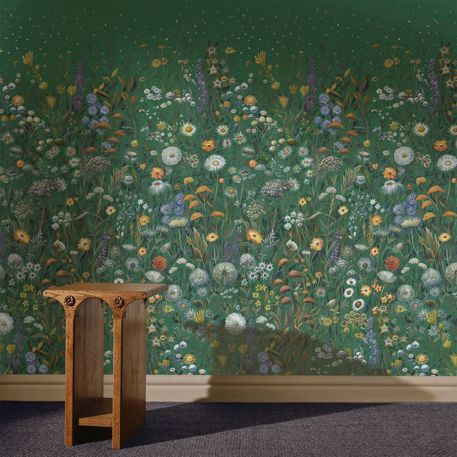 a table next to a wall with a painting of flowers
