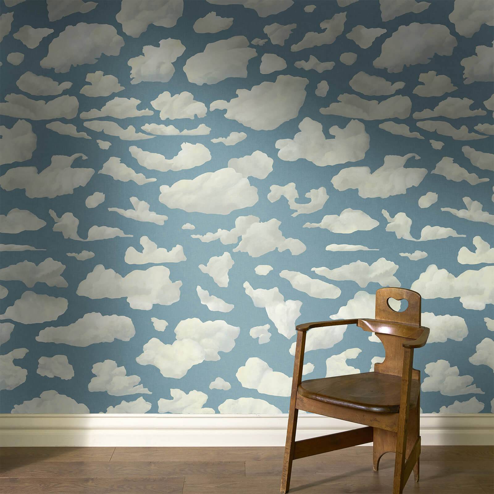 a chair in a room with clouds wallpaper